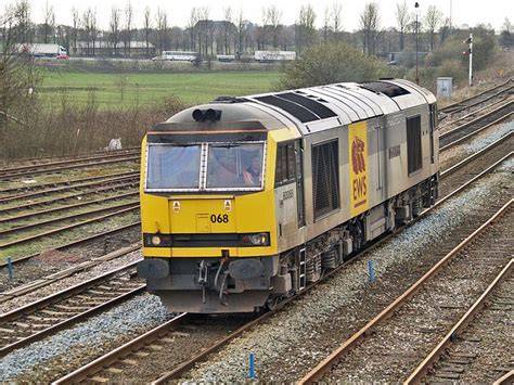 A British Rail Class 60 locomotive actively transporting freight containers on a train.