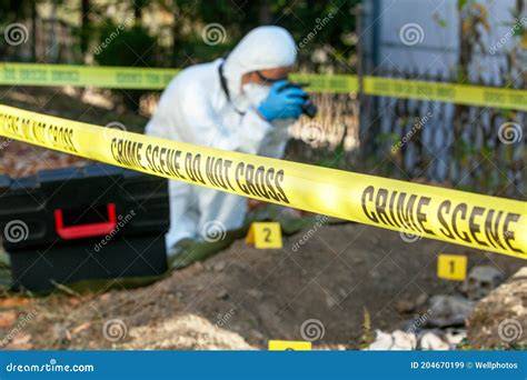 A police officer examining evidence at a crime scene associated with John Wayne Gacy's murders.