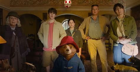 Paddington Bear smiling with the Brown family in their cozy living room