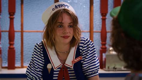 Maya Hawke dressed in 1980s attire with a skateboard