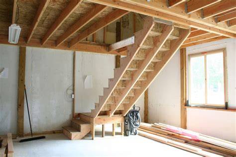 Workers constructing dog-leg stairs at a construction site.