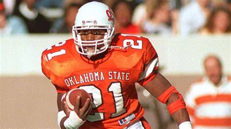 Barry Sanders, wearing a Cowboys jersey, running with the football during a game.