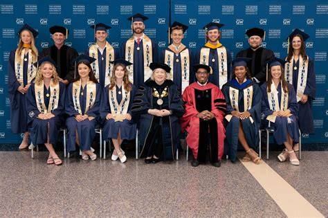 Notable alumni from George Washington University standing on a stage receiving awards.