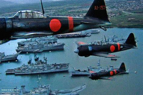 Japanese Zero fighter planes swooping down towards a naval base in an aerial attack.