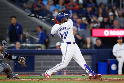 Vladimir Guerrero Jr. in action, swinging at a pitch during a game.