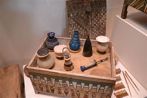A collection of ancient Egyptian grave goods including pottery and tools placed inside a tomb.