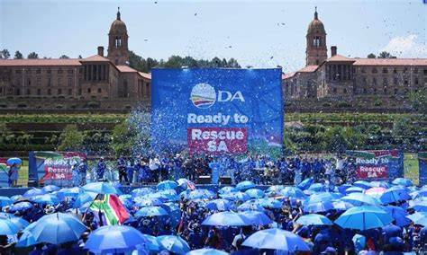A bustling campaign event for the Democratic Alliance with banners and supporters.