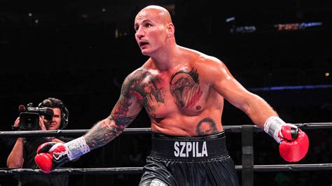 Artur Szpilka raises his arms in victory after a successful fight.