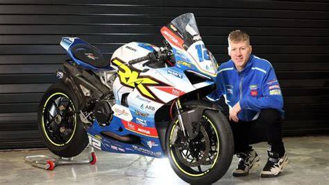 Ian Hutchinson is examining new motorcycle technology at a racing event.