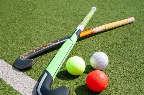 A selection of field hockey equipment including sticks and balls displayed together.